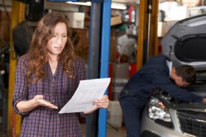 woman looking at auto repair bill